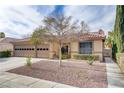 Inviting home featuring a red-tiled roof, desert landscaping, and a well-maintained front yard at 1202 Healing Waters Ln, North Las Vegas, NV 89031