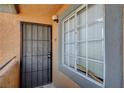 Apartment front door with security screen next to large window with privacy blinds at 220 Mission Catalina Ln # 207, Las Vegas, NV 89107