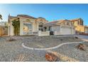 A single-story home with a three-car garage and minimalist landscaping featuring a drought-tolerant design at 2221 Loggerhead Rd, Las Vegas, NV 89117