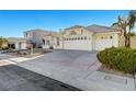 A single-story home showcases a three-car garage, concrete driveway, and xeriscaping for low maintenance at 2221 Loggerhead Rd, Las Vegas, NV 89117