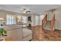Bright living room features a ceiling fan, plush furniture, and staircase, creating a comfortable and inviting space at 2376 Via Firenze, Henderson, NV 89044