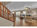 Open-concept living area with wood staircase, tile flooring, and bright windows allows for seamless entertaining at 2376 Via Firenze, Henderson, NV 89044