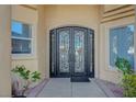 Elegant wrought iron double front doors add curb appeal to this home with a tiled walkway at 2705 Crystal Beach Dr, Las Vegas, NV 89128