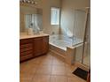 Bright bathroom features a soaking tub, glass-enclosed shower, and a vanity with ample storage space at 3609 Citrus Heights Ave, North Las Vegas, NV 89081