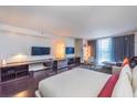 Spacious main bedroom featuring an entertainment center, stylish hardwood flooring, and floor-to-ceiling windows at 4381 W Flamingo Rd # 1019, Las Vegas, NV 89103