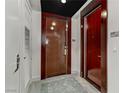 Condo entrance with a dark wood door, neutral rug, and modern fixtures, creating a welcoming and secure feel at 4575 Dean Martin Dr # 1811, Las Vegas, NV 89103