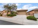 Charming home featuring desert landscaping, mature tree and a two-car garage at 6138 Equine Ave, Las Vegas, NV 89122