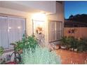 Inviting outdoor patio with secure gated entryway, lush plants, and outdoor lighting at 6412 Big Pine Way, Las Vegas, NV 89108