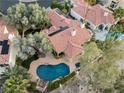 An aerial view of the home featuring a private pool, mature trees, and desert landscaping at 7608 Painted Dunes Dr, Las Vegas, NV 89149