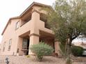 Exterior home elevation featuring a balcony, neutral paint, and well-manicured landscaping at 8070 Pavarotti Ave, Las Vegas, NV 89178