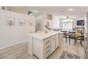 Open-concept kitchen featuring a large island with bar seating, light wood floors, and stainless steel appliances at 8136 Shady Glen Ave, Las Vegas, NV 89131