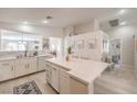 Well-lit kitchen features white cabinets, countertops and backsplash, plus a large island with bar-style seating at 8136 Shady Glen Ave, Las Vegas, NV 89131