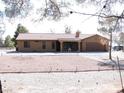 Inviting single-story house with tile roof, desert landscaping, and covered porch entrance at 1081 Pluto St, Pahrump, NV 89048