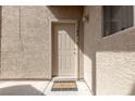 Condo entrance with a welcome mat, textured walls, and stylish exterior lighting at 2160 Highpointe Dr # 103, Laughlin, NV 89029