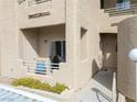 Exterior view of a condominium showcasing a balcony, patio, and textured stucco walls at 2160 Highpointe Dr # 103, Laughlin, NV 89029