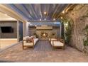 Charming outdoor patio with a fireplace, covered pergola, string lights, and modern seating at 258 Castellari Dr, Las Vegas, NV 89138