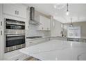 Well-equipped kitchen with quartz countertops, stainless steel appliances, and designer lighting fixtures at 2603 Savannah Springs Ave, Henderson, NV 89052