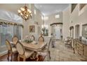 Formal dining room with high ceilings, a decorative chandelier, and large windows overlooking the front yard at 3728 Russell Peterson Ct, Las Vegas, NV 89129