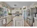 Well-equipped kitchen with stainless steel appliances, island, and custom white cabinets at 3728 Russell Peterson Ct, Las Vegas, NV 89129