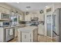 Well-lit kitchen with stainless steel appliances, an island, and custom cabinetry at 3728 Russell Peterson Ct, Las Vegas, NV 89129