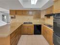 Well-lit kitchen features tile flooring, wood cabinets, granite countertops, and modern appliances at 3759 Mckinley Cir, Las Vegas, NV 89121