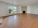 Spacious living room features hardwood floors, a cozy fireplace, and natural light streaming through large windows at 3759 Mckinley Cir, Las Vegas, NV 89121