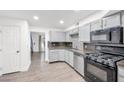 Modern kitchen with stainless steel appliances, stylish backsplash, and wood flooring at 3944 Visby Ln, Las Vegas, NV 89119