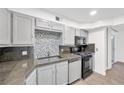 Bright kitchen with modern appliances, neutral gray cabinets, and stylish backsplash at 3944 Visby Ln, Las Vegas, NV 89119