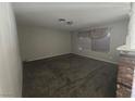 View of the Living room featuring a small window, light gray paint and dark carpet at 4013 El Camino Ave, Las Vegas, NV 89102
