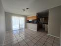 An open living space with a view of the kitchen, tile floors, and sliding glass doors to the outside at 4013 El Camino Ave, Las Vegas, NV 89102