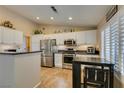Bright kitchen with stainless steel appliances, white cabinets, and a breakfast bar at 455 Paulson Dr, Las Vegas, NV 89123