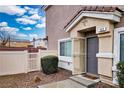 Inviting front entrance featuring a screened door, complemented by a white fence and manicured landscaping at 4850 Straight Flush Dr # 103, Las Vegas, NV 89122