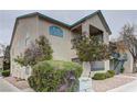 Multi-story building featuring an outdoor balcony, manicured shrubs, and beige stucco siding at 5161 Lindell Rd # 201, Las Vegas, NV 89118