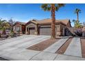 Gorgeous home featuring a desert landscape, tile roof, and long driveway leading up to a three-car garage at 563 Moon Chase St, Las Vegas, NV 89110