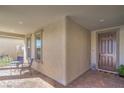 Covered porch with tiled flooring, seating, and an attractive entryway door at 6593 Corsari Ridge St, Las Vegas, NV 89166
