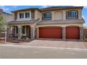Elegant two-story home boasting a three-car garage, stone detailing, and a charming front entrance at 7255 Bold Rock Ave, Las Vegas, NV 89113