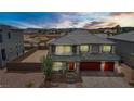 Inviting two-story home with a red front door, three-car garage, and sunset views at 7255 Bold Rock Ave, Las Vegas, NV 89113