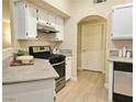 Well-lit kitchen with a gas range, white cabinets, and wood-look flooring at 9000 S Las Vegas Blvd # 1187, Las Vegas, NV 89123