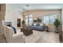 Bright living room featuring a ceiling fan, neutral walls, a fireplace, and multiple windows at 914 Calico Brook Dr, Henderson, NV 89002