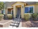 Inviting front porch with a gray door, wreath, and lovely front garden at 965 Nevada State Dr # 36102, Henderson, NV 89002