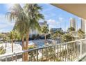 Balcony view featuring lush palms, tennis courts, and a pool creating a tropical urban oasis at 205 E Harmon Ave # 707, Las Vegas, NV 89169
