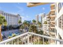 Balcony with views of tennis courts, a pool, lush palms and buildings for luxurious city living at 205 E Harmon Ave # 707, Las Vegas, NV 89169