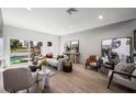 Sun-lit living room with wood floors, neutral decor, and backyard pool view at 2861 Queens Courtyard Dr, Las Vegas, NV 89109