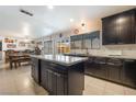 Updated kitchen with granite counters, stainless appliances, dark wood cabinetry and an island with seating at 3920 Clear View Dr, Las Vegas, NV 89121