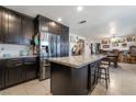 Open kitchen boasts dark wood cabinets, stainless steel appliances and an island with seating at 3920 Clear View Dr, Las Vegas, NV 89121