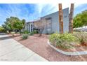 Condo building exterior featuring lush landscaping, desert scape, and a charming walkway at 5199 Caliente St # 63, Las Vegas, NV 89119