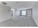 Spacious living room with gray carpet, neutral walls, and a bright window creating a cozy atmosphere at 5199 Caliente St # 63, Las Vegas, NV 89119
