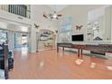 Open living room with vaulted ceilings, a decorative fireplace, and sliding door to the patio at 6116 Golden Saddle St, Las Vegas, NV 89130