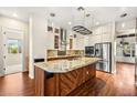 Modern kitchen features a large center island, stainless steel appliances, custom cabinets, and granite countertops at 6907 May Basket Ave, Las Vegas, NV 89131