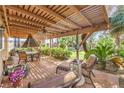 Relaxing outdoor patio area featuring a wooden pergola, seating, and well-maintained landscaping at 7211 Galley Dr, Las Vegas, NV 89147